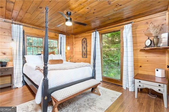 bedroom featuring wood finished floors, wood ceiling, and wooden walls