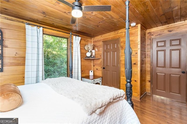 bedroom with wooden ceiling, wooden walls, and wood finished floors