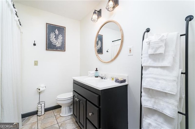 bathroom featuring toilet, tile patterned floors, baseboards, and vanity