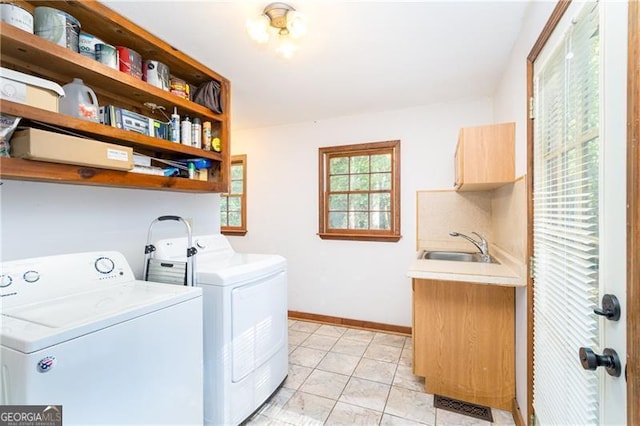 laundry area with cabinet space, visible vents, baseboards, washing machine and dryer, and a sink