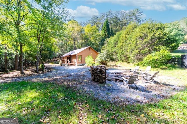 view of yard featuring an outdoor fire pit and an outdoor structure