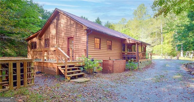 view of property exterior featuring driveway and a wooden deck