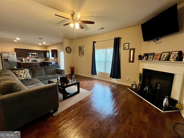 living room featuring dark hardwood / wood-style flooring and ceiling fan