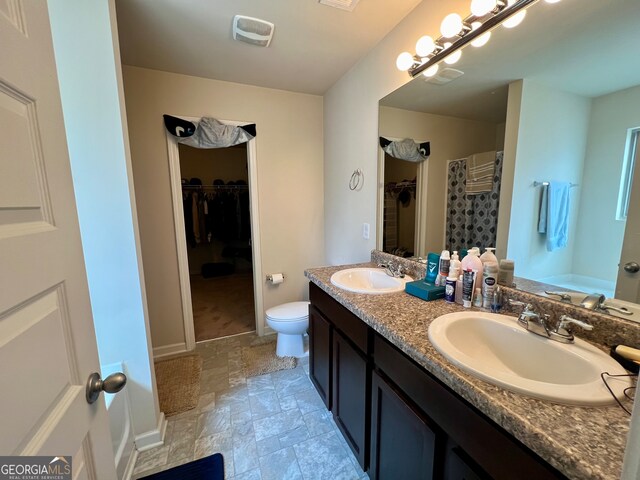 bathroom featuring walk in shower, vanity, and toilet