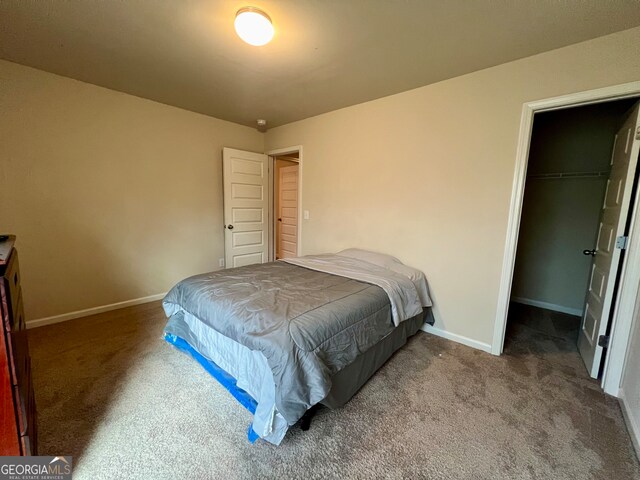 carpeted bedroom with a closet and a walk in closet