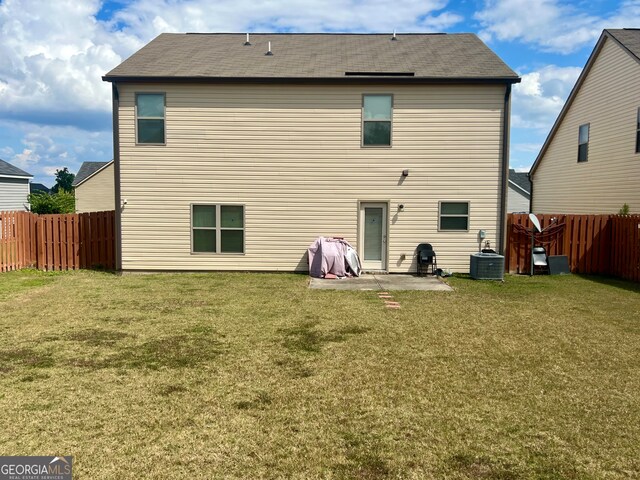 back of house featuring a lawn, a patio, and central AC