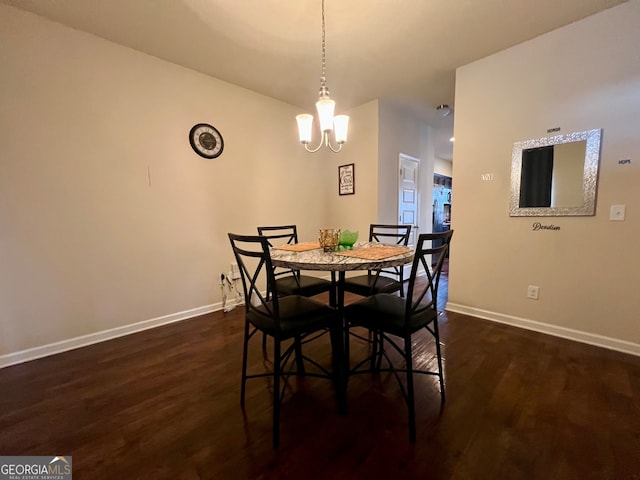 dining area featuring dark wood-type flooring and a chandelier