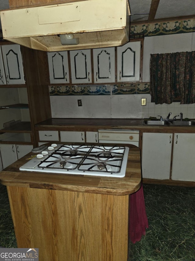 kitchen featuring exhaust hood, white gas stovetop, and sink