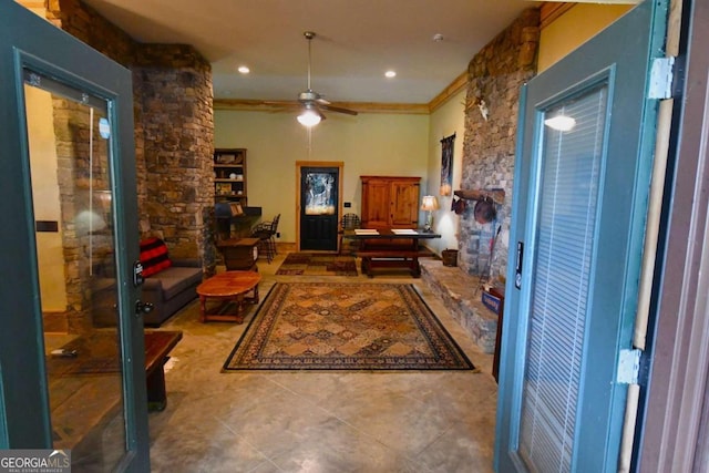 living room with light tile patterned flooring, ornamental molding, and ceiling fan