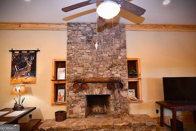 living room with ceiling fan and a stone fireplace