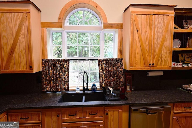 kitchen featuring dark stone counters, dishwasher, backsplash, and sink