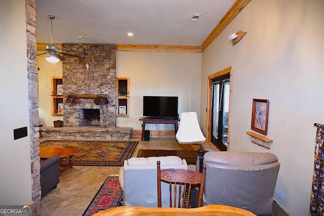 living room with crown molding, a stone fireplace, and ceiling fan