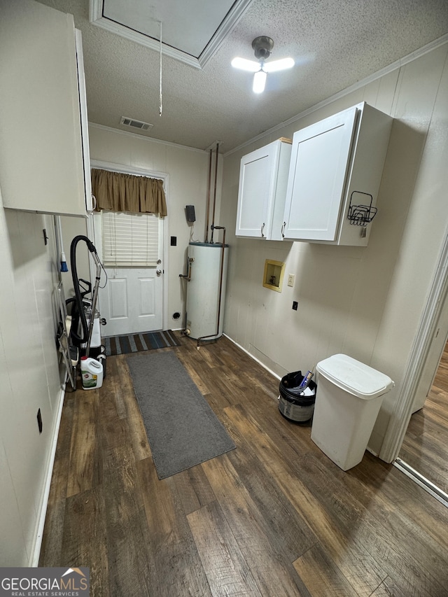 interior space with a textured ceiling, gas water heater, ornamental molding, and hardwood / wood-style flooring