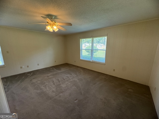 carpeted spare room with a textured ceiling, ornamental molding, and ceiling fan