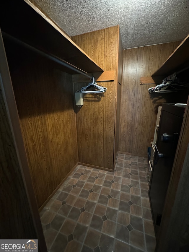 walk in closet featuring dark tile patterned floors