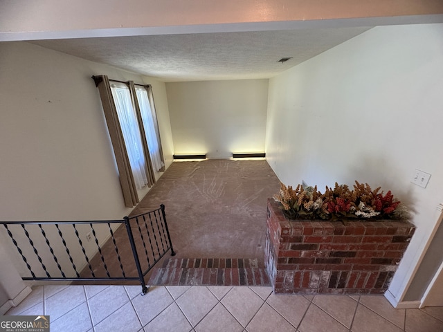 staircase featuring a textured ceiling and tile patterned flooring