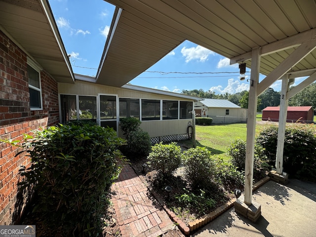 view of patio featuring a storage unit and a sunroom