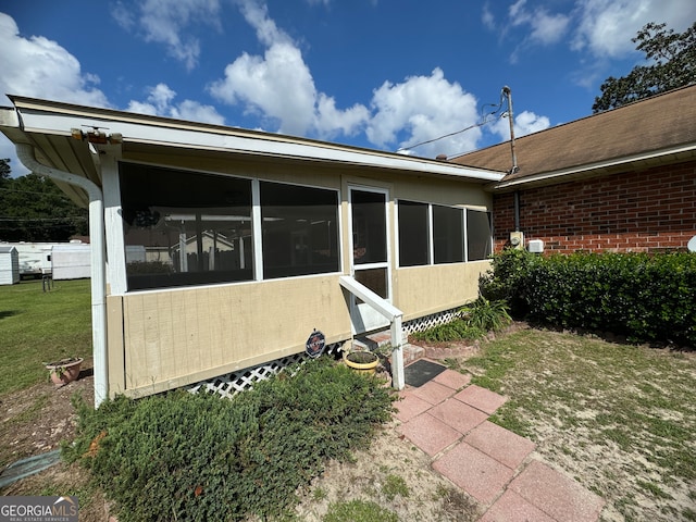 exterior space featuring a sunroom and a yard