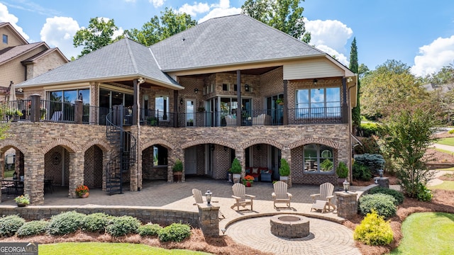 back of house featuring a patio area, a balcony, and a fire pit