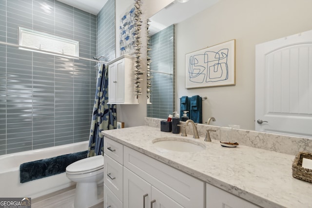 bathroom with vanity, shower / bath combo with shower curtain, and toilet