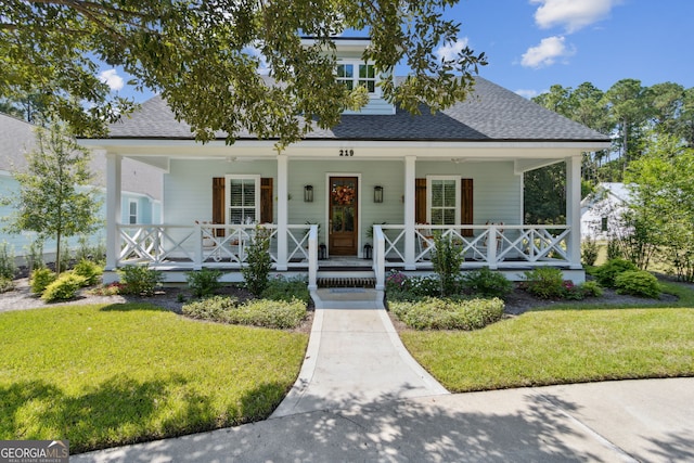 view of front of house featuring a porch, a shingled roof, and a front lawn