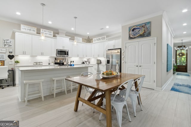 dining area featuring baseboards, light wood finished floors, recessed lighting, and crown molding