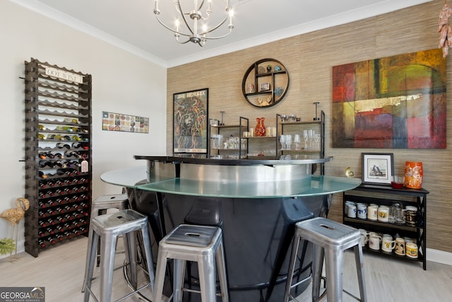 bar with a chandelier, crown molding, baseboards, and wood finished floors