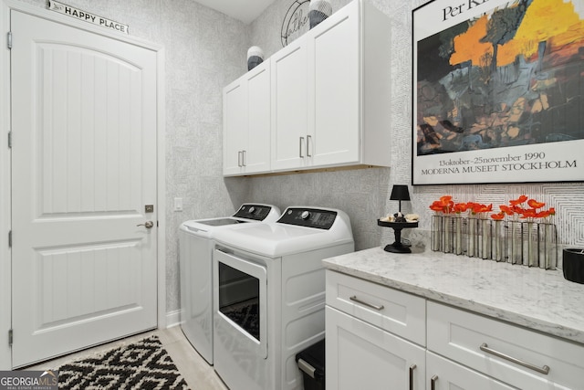 washroom with cabinet space, light tile patterned floors, and separate washer and dryer