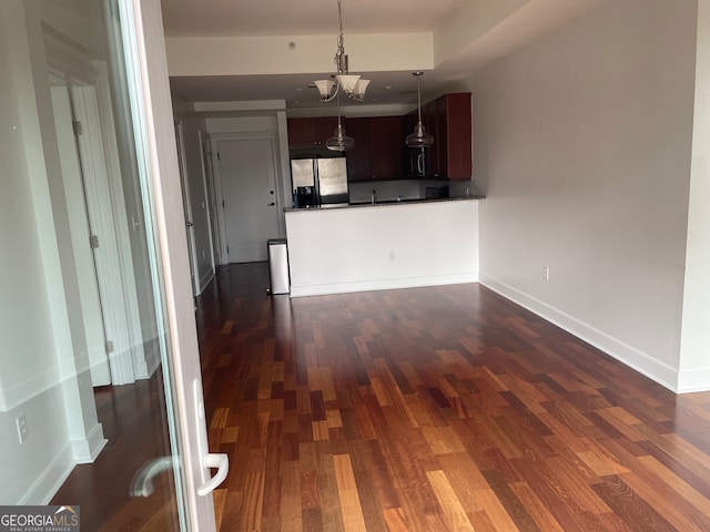 kitchen with dark brown cabinets, stainless steel fridge with ice dispenser, dark wood-type flooring, and hanging light fixtures