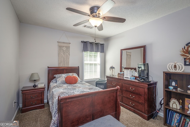 carpeted bedroom featuring ceiling fan and a textured ceiling