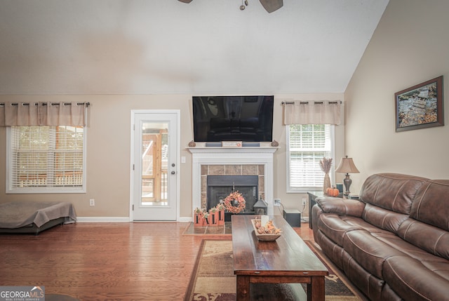 living room featuring ceiling fan, a fireplace, hardwood / wood-style floors, and lofted ceiling