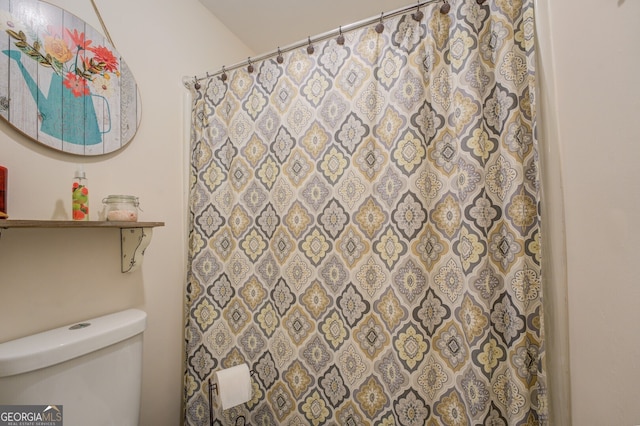 bathroom featuring toilet and a shower with shower curtain