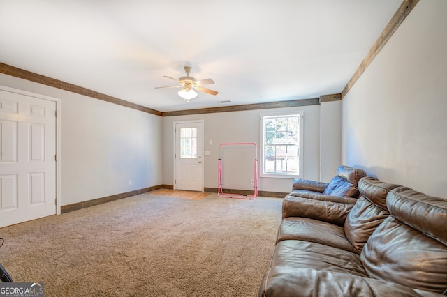 living room featuring ornamental molding, ceiling fan, and light colored carpet