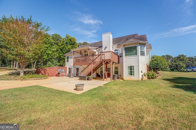 rear view of house with a patio, a lawn, and a wooden deck