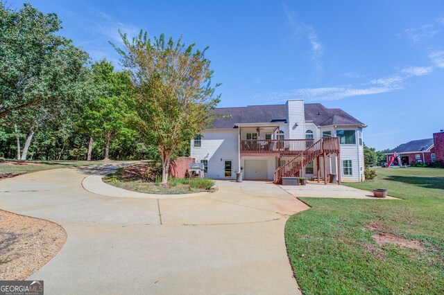 rear view of property with a lawn and a garage