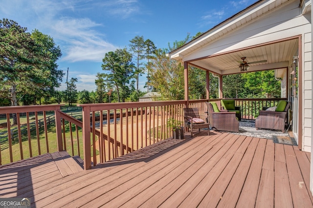 wooden deck with a yard and ceiling fan