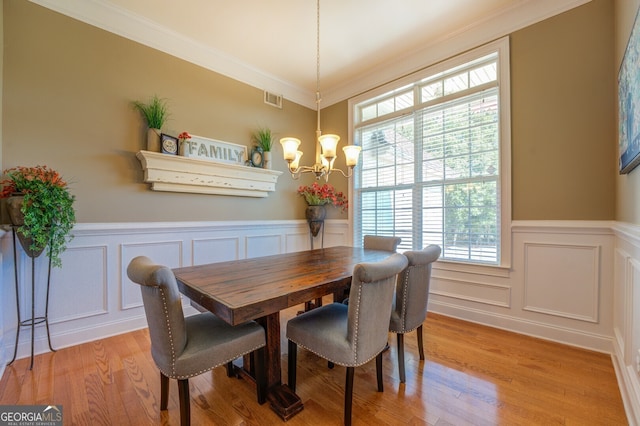 dining room featuring ornamental molding, light hardwood / wood-style floors, and a healthy amount of sunlight