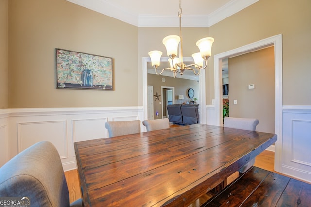 dining space with a notable chandelier, crown molding, and dark hardwood / wood-style flooring