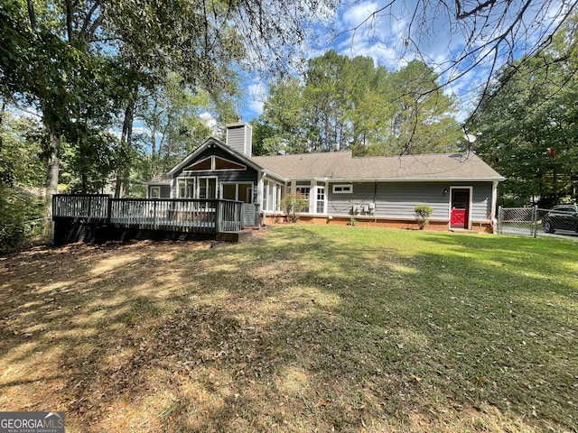 back of property featuring a wooden deck and a yard