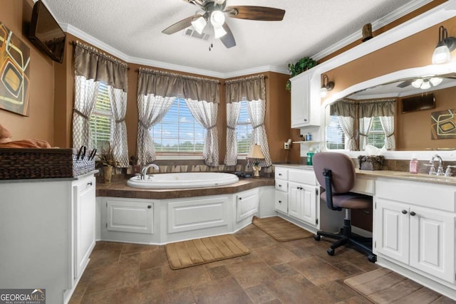 bathroom featuring a textured ceiling, ornamental molding, a bathing tub, and ceiling fan