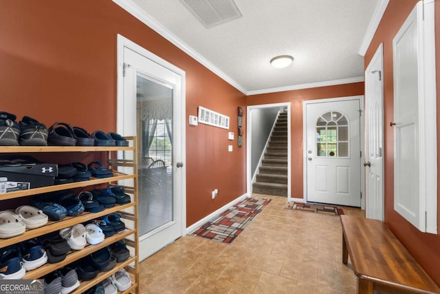 entryway with a textured ceiling, ornamental molding, light tile patterned floors, and a wealth of natural light