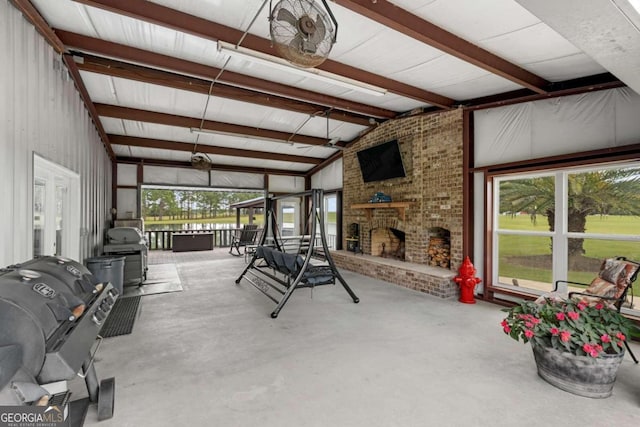 sunroom / solarium featuring vaulted ceiling with beams and a fireplace