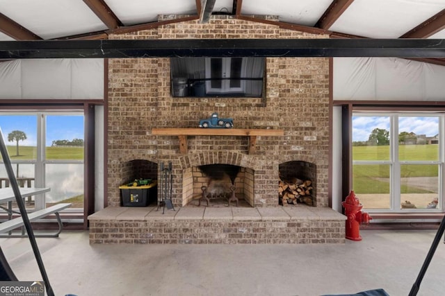 living room featuring lofted ceiling with beams, a wealth of natural light, and a fireplace