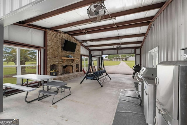 interior space with vaulted ceiling with beams and an outdoor brick fireplace