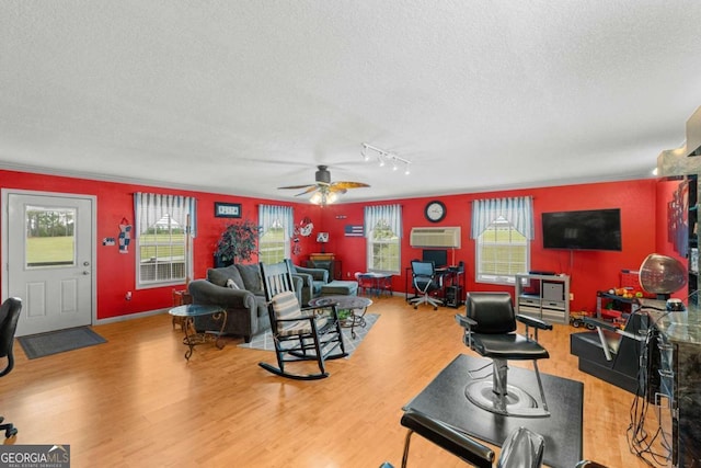 living room with ceiling fan, ornamental molding, a textured ceiling, and hardwood / wood-style floors