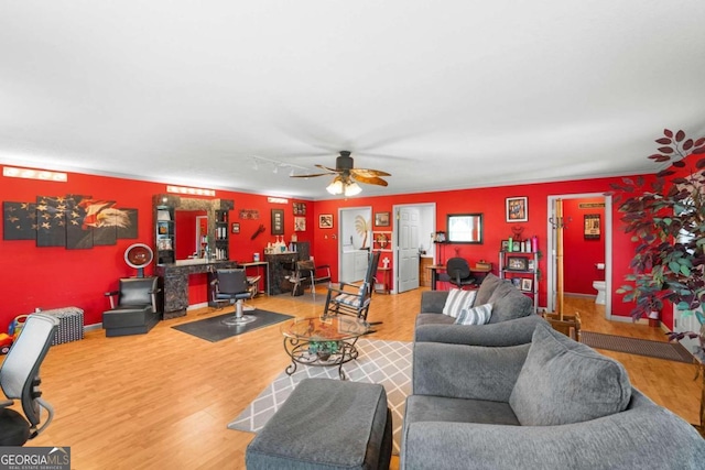 living room with wood-type flooring and ceiling fan