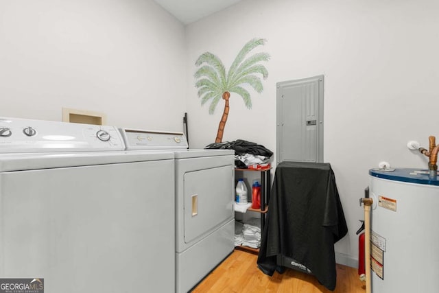 washroom featuring water heater, light hardwood / wood-style floors, electric panel, and independent washer and dryer