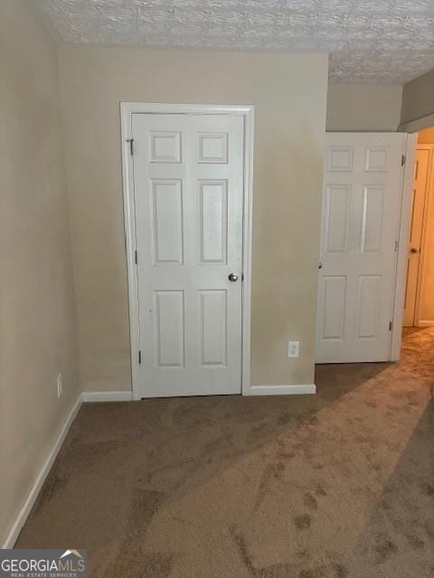 unfurnished bedroom featuring a textured ceiling and carpet flooring