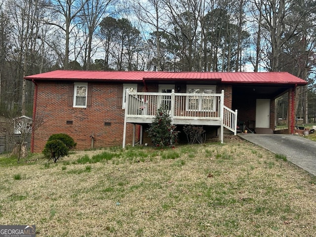 ranch-style home featuring a carport, a deck, and a front yard