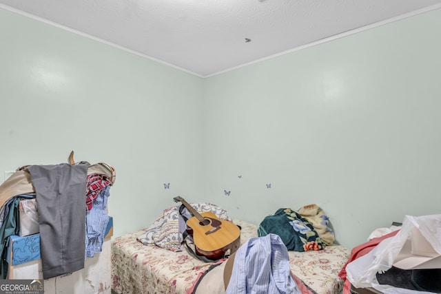 bedroom featuring ornamental molding and a textured ceiling